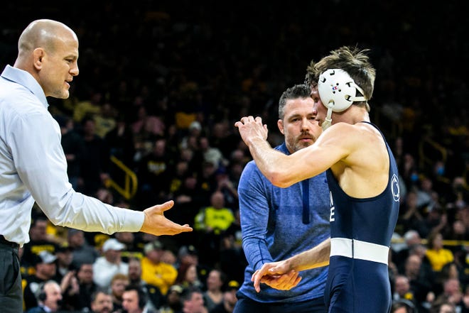 Penn State head coach Cael Sanderson, left, high-fives wrestler Drew Hildebrandt after his major decision win at 125 pounds during a NCAA Big Ten Conference wrestling dual against Iowa, Friday, Jan. 28, 2022, at Carver-Hawkeye Arena in Iowa City, Iowa.