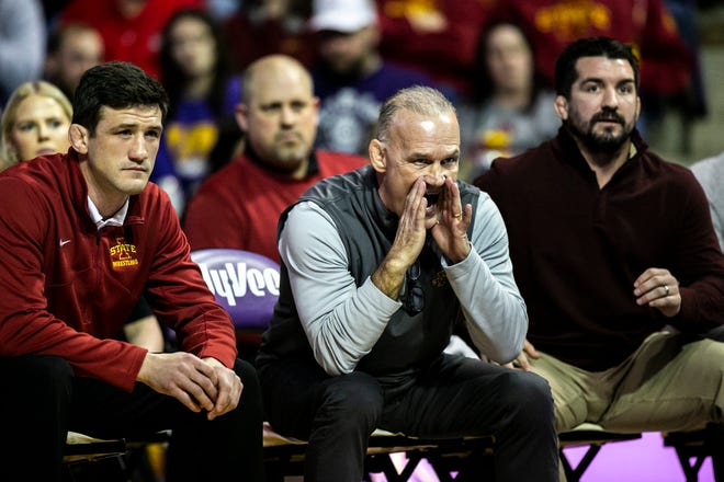 Iowa State head coach Kevin Dresser, center, calls out instructions to a wrestler as assistants Derek St. John, left, and Brent Metcalf look on during a NCAA college Big 12 wrestling dual against Northern Iowa, Friday, Feb. 11, 2022, at the McLeod Center in Cedar Falls, Iowa.