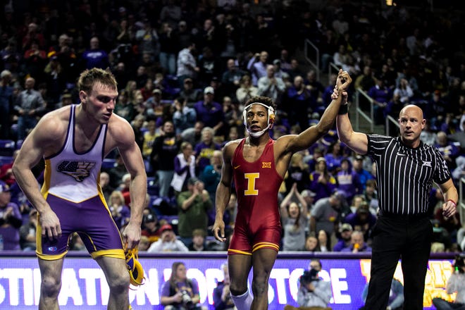 Iowa State's David Carr, center, has his hand raised after scoring a decision against Northern Iowa's Derek Holschlag, left, at 157 pounds during a NCAA college Big 12 wrestling dual, Friday, Feb. 11, 2022, at the McLeod Center in Cedar Falls, Iowa.