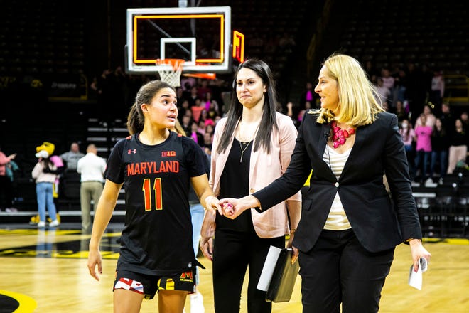 Maryland guard Katie Benzan (11) holds hands with Maryland head coach Brenda Frese as they walk off the court after a NCAA Big Ten Conference women's basketball game against Iowa, Monday, Feb. 14, 2022, at Carver-Hawkeye Arena in Iowa City, Iowa.
