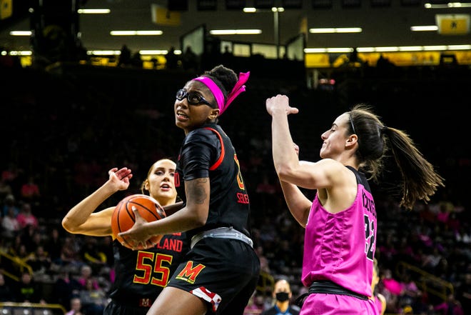 Maryland guard Shyanne Sellers (0) drives against Iowa guard Caitlin Clark (22) as Maryland's Chloe Bibby (55) looks on during a NCAA Big Ten Conference women's basketball game, Monday, Feb. 14, 2022, at Carver-Hawkeye Arena in Iowa City, Iowa.