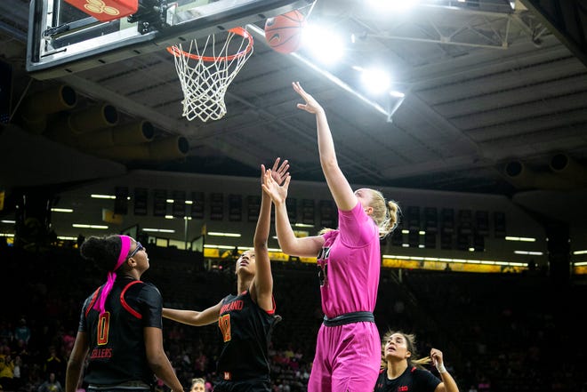 Iowa's Addison O'Grady (44) makes a basket as Maryland guard Shyanne Sellers (0) and Maryland's Angel Reese (10) defend during a NCAA Big Ten Conference women's basketball game, Monday, Feb. 14, 2022, at Carver-Hawkeye Arena in Iowa City, Iowa.