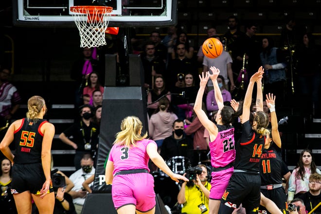 Iowa guard Caitlin Clark (22) shoots a basket as Maryland guards Taisiya Kozlova (14) and Katie Benzan (11) defend during a NCAA Big Ten Conference women's basketball game, Monday, Feb. 14, 2022, at Carver-Hawkeye Arena in Iowa City, Iowa.