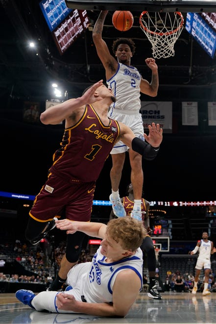 Loyola of Chicago's Lucas Williamson (1) shoots as Drake's Tucker Devries (12) and Tremell Murphy (2) defend during the first half of an NCAA college basketball game in the championship of the Missouri Valley Conference tournament Sunday, March 6, 2022, in St. Louis. (AP Photo/Jeff Roberson)