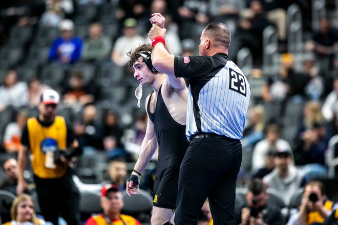 Iowa's Austin DeSanto, left, has his hand raised after scoring a decision at 133 pounds for third place during the fifth session of the NCAA Division I Wrestling Championships, Saturday, March 19, 2022, at Little Caesars Arena in Detroit, Mich.