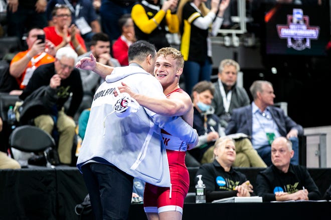NC State's Hayden Hidlay celebrates with coaches after scoring a decision at 174 pounds for third place during the fifth session of the NCAA Division I Wrestling Championships, Saturday, March 19, 2022, at Little Caesars Arena in Detroit, Mich.