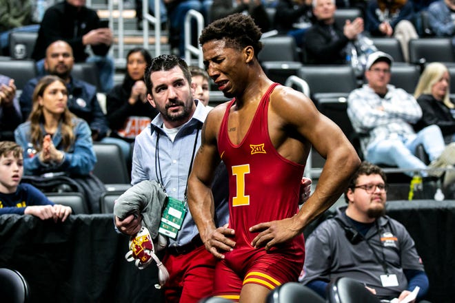 Iowa State's David Carr, right, reacts while walking with assistant coach Brent Metcalf after scoring a decision at 157 pounds for third place during the fifth session of the NCAA Division I Wrestling Championships, Saturday, March 19, 2022, at Little Caesars Arena in Detroit, Mich.
