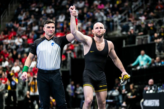 Iowa's Alex Marinelli has his hand raised after winning a medical forfeit at 165 pounds for fifth place during the fifth session of the NCAA Division I Wrestling Championships, Saturday, March 19, 2022, at Little Caesars Arena in Detroit, Mich.