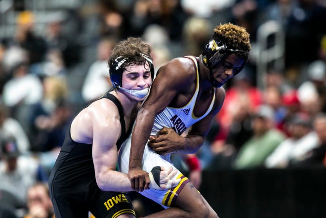 Iowa's Austin DeSanto, left, wrestles Arizona State's Michael McGee at 133 pounds for third place during the fifth session of the NCAA Division I Wrestling Championships, Saturday, March 19, 2022, at Little Caesars Arena in Detroit, Mich.