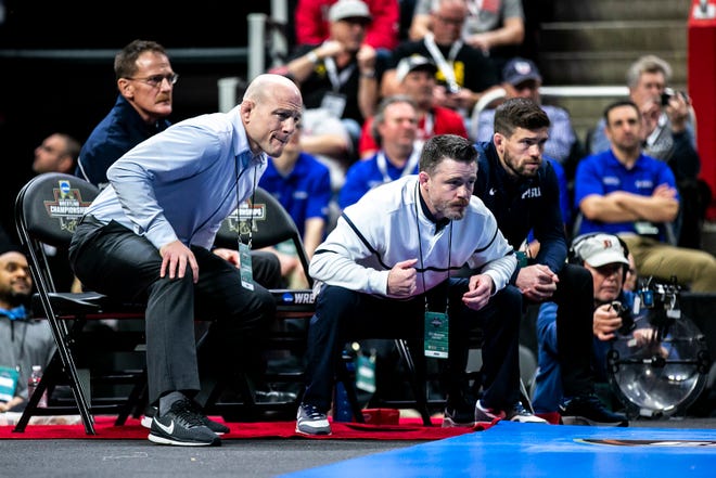 Penn State head coach Cael Sanderson, left, watches in the finals of the 133 pounds match during the sixth session of the NCAA Division I Wrestling Championships, Saturday, March 19, 2022, at Little Caesars Arena in Detroit, Mich.
