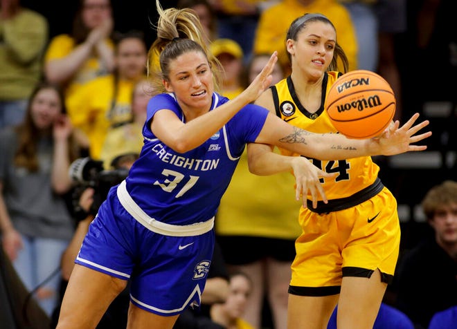Creighton forward Emma Ronsiek (31) and Iowa guard Gabbie Marshall (24) reach for a loose ball during the second half of a second-round game in the NCAA women's college basketball tournament, Sunday, March 20, 2022, in Iowa City, Iowa. (AP Photo/Ron Johnson)
