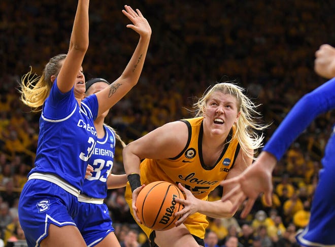 Iowa forward Monika Czinano (25) drives past Creighton forward Emma Ronsiek (31)during the second half of a second-round game in the NCAA women's college basketball tournament, Sunday, March 20, 2022, in Iowa City, Iowa. (AP Photo/Ron Johnson)