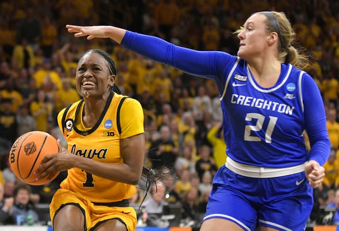 Creighton guard Molly Mogensen (21) tries to block a drive to the basket by Iowa guard Tomi Taiwo (1) during the second half of a second-round game in the NCAA women's college basketball tournament, Sunday, March 20, 2022, in Iowa City, Iowa. (AP Photo/Ron Johnson)
