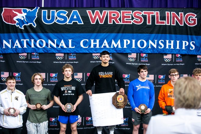 Hunter Garvin, center, poses for a photo atop the podium for 152 pounds after scoring a fall in the finals during the USA Wrestling High School National Recruiting Showcase, Saturday, April 2, 2022, at the UNI-Dome in Cedar Falls, Iowa.