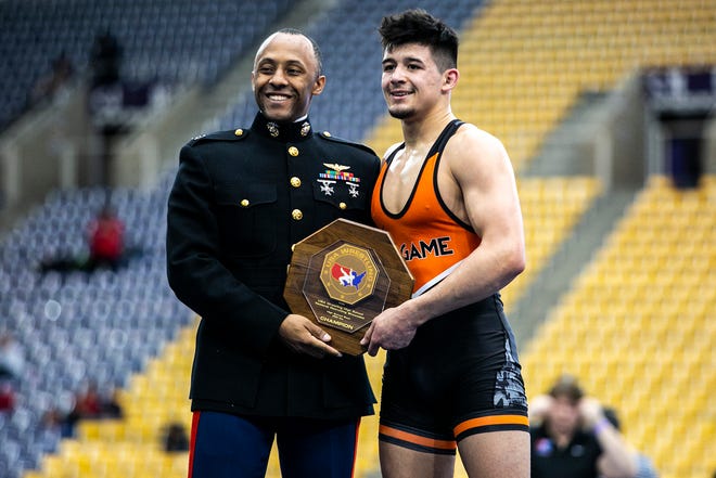 Hunter Garvin, right, poses for a photo with his trophy after scoring a fall at 152 pounds in the finals during the USA Wrestling High School National Recruiting Showcase, Saturday, April 2, 2022, at the UNI-Dome in Cedar Falls, Iowa.