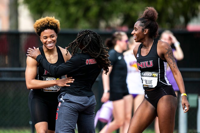 Northern Illinois University's Malia Watkins, left, is embraced by teammates after winning the 100 meter dash during the Musco Twilight NCAA outdoor track and field meet, Saturday, April 23, 2022, at Francis X. Cretzmeyer Track in Iowa City, Iowa.