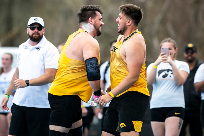 Iowa's Nik Curtiss, left, celebrates with teammates after setting a school record in shot put during the Musco Twilight NCAA outdoor track and field meet, Saturday, April 23, 2022, at Francis X. Cretzmeyer Track in Iowa City, Iowa.