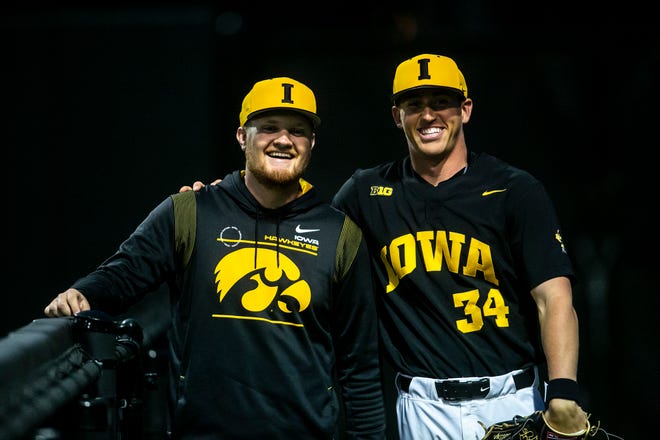 Iowa baseball head manager Scott Junck, left, poses for a photo with pitcher Luke Llewellyn (34) during a NCAA Big Ten Conference baseball game against Indiana, Friday, May 20, 2022, at Duane Banks Field in Iowa City, Iowa.
