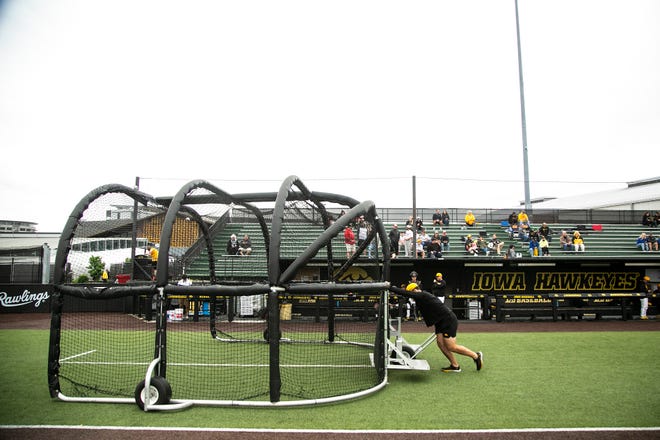 Iowa baseball managers clear batting practice equipment from the field before a NCAA Big Ten Conference baseball game against Indiana, Friday, May 20, 2022, at Duane Banks Field in Iowa City, Iowa.