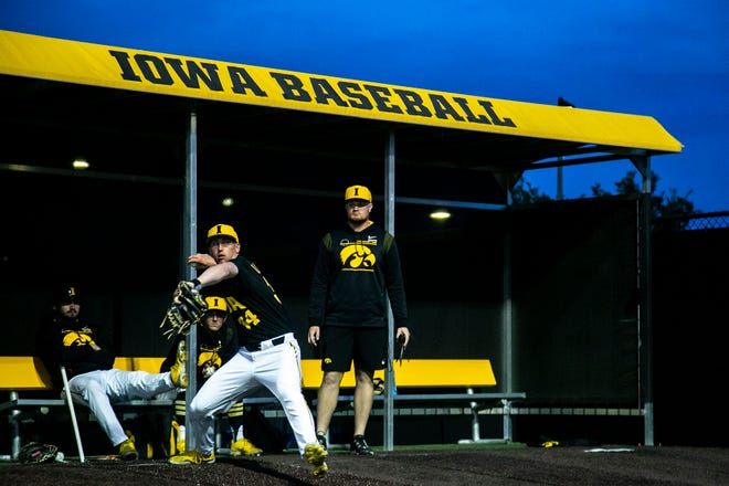 Iowa baseball head manager Scott Junck watches as pitcher Luke Llewellyn (34) warms up during a NCAA Big Ten Conference baseball game against Indiana, Friday, May 20, 2022, at Duane Banks Field in Iowa City, Iowa.
