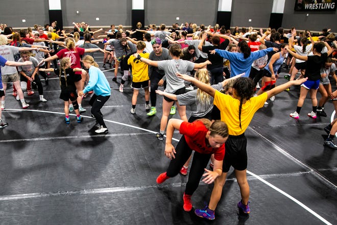 Campers warm up during a girls wrestling technique camp, Wednesday, July 6, 2022, at the GreenState Family Fieldhouse in Coralville, Iowa.