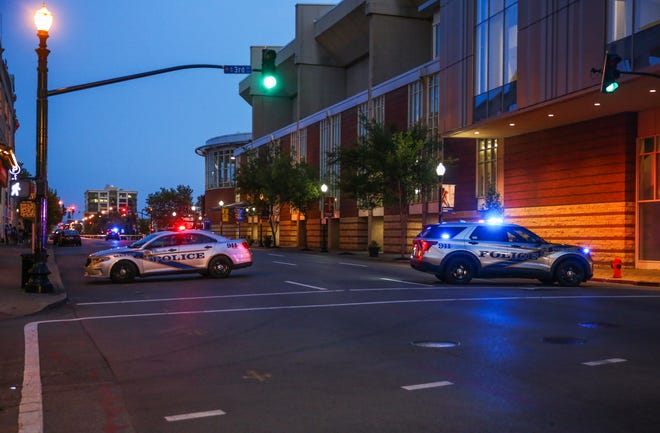 Police officers investigate the scene on Second Street and East Market Street where a driver struck pedestrians in downtown Louisville on July 5, 2022. A man was taken into custody and charged with impairment and three adults and one child were taken to the UofL and Norton Children's Hospital.