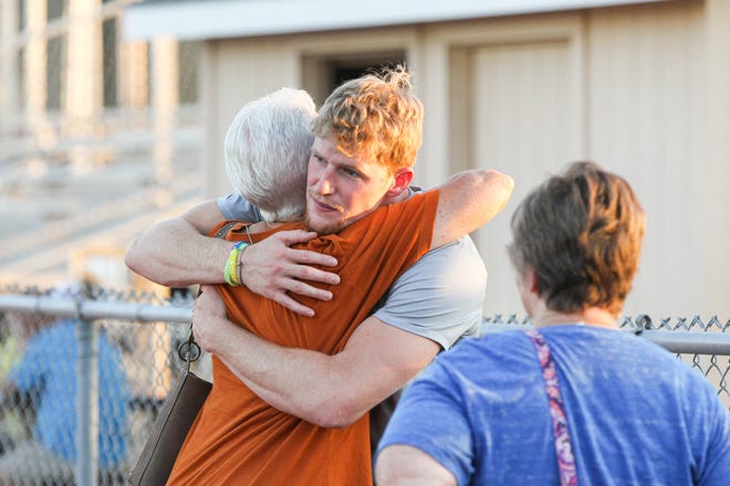 Hunter Jones receives a hug after visiting with attendees at the community field night Saturday, Aug. 13, 2022 at Don Michael Field in Hutchinson.