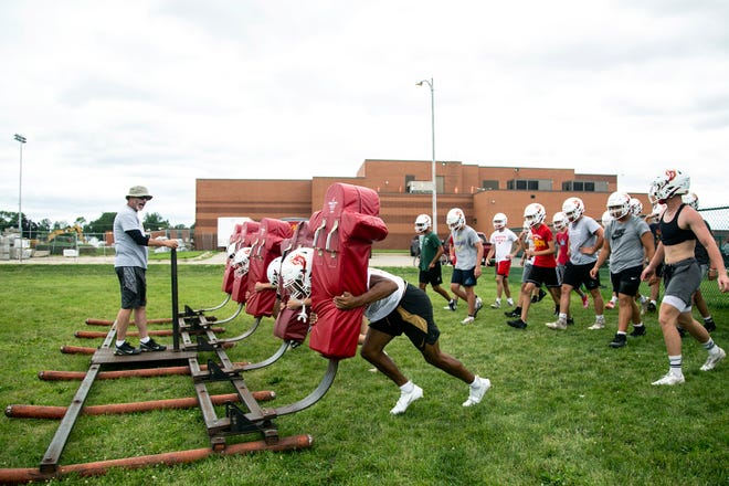 Marion's Alex Mota, foreground center, pushes a sled with teammates during a high school football practice, Monday, Aug. 8, 2022, at Marion High School in Marion, Iowa.