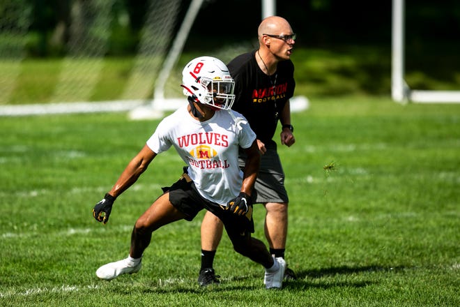Marion's Alex Mota makes a cut past head coach Michael Joyner during a high school football practice, Monday, Aug. 8, 2022, at Marion High School in Marion, Iowa.