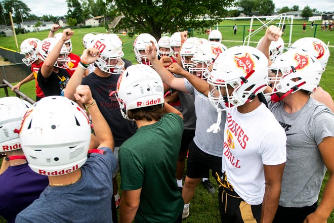 Marion's Alex Mota, second from right, huddles up with teammates after a drill during a high school football practice, Monday, Aug. 8, 2022, at Marion High School in Marion, Iowa.