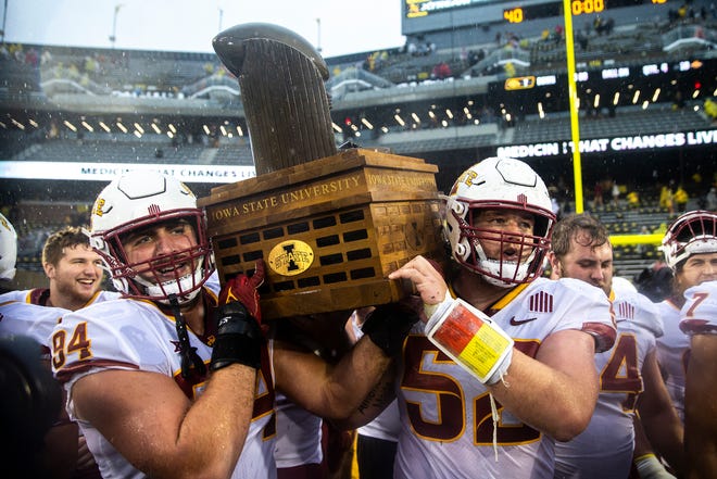 Iowa State players Kyle Krezek, left, and Trevor Downing celebrate with the Cy-Hawk trophy after a NCAA football game against Iowa, Saturday, Sept. 10, 2022, at Kinnick Stadium in Iowa City, Iowa.