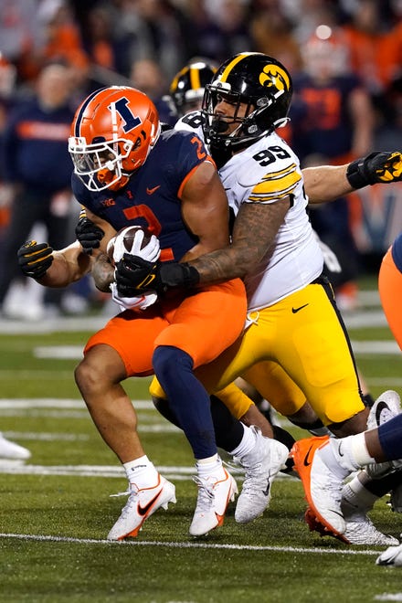 Iowa defensive lineman Noah Shannon tackles Illinois running back Chase Brown during the first half of an NCAA college football game Saturday, Oct. 8, 2022, in Champaign, Ill. (AP Photo/Charles Rex Arbogast)