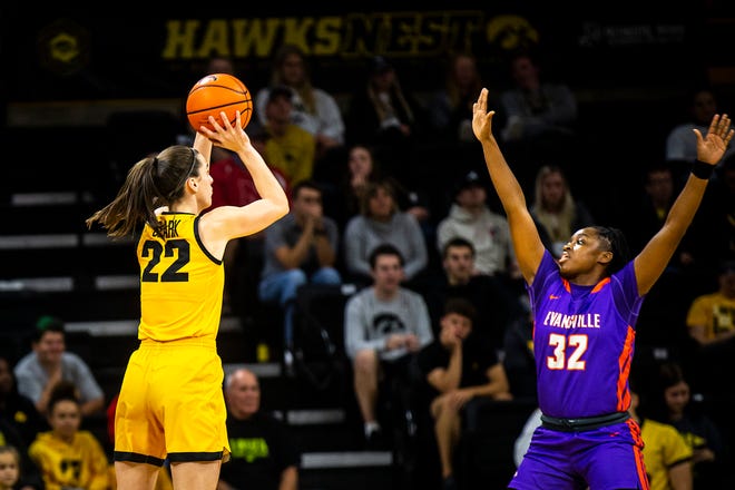 Iowa guard Caitlin Clark (22) shoots a 3-point basket as Evansville guard Myia Clark (32) defends during a NCAA women's basketball game, Thursday, Nov. 10, 2022, at Carver-Hawkeye Arena in Iowa City, Iowa.