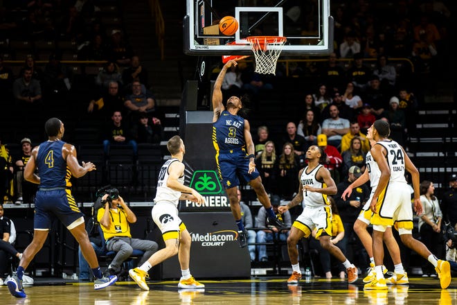 North Carolina A&T guard Kam Woods (3) makes a basket as Iowa guards Connor McCaffery, left, and Ahron Ulis defend during a NCAA men's basketball game, Friday, Nov. 11, 2022, at Carver-Hawkeye Arena in Iowa City, Iowa.