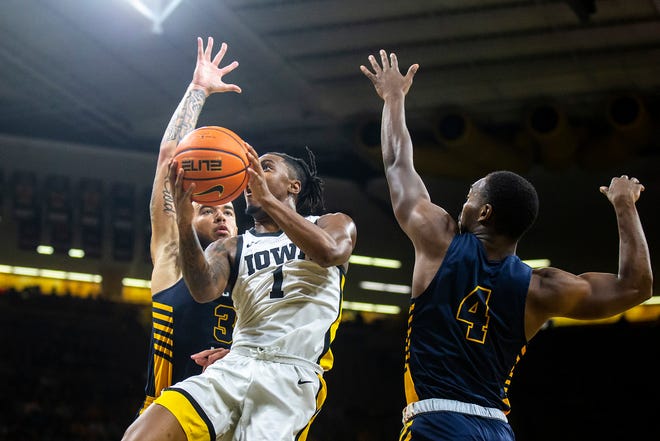 Iowa guard Ahron Ulis (1) shoots a basket as North Carolina A&T forward Duncan Powell, left, and Marcus Watson during a NCAA men's basketball game, Friday, Nov. 11, 2022, at Carver-Hawkeye Arena in Iowa City, Iowa.