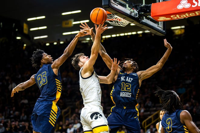 Iowa forward Filip Rebraca, center, shoots the ball as North Carolina A&T forwards Webster Filmore and Austin Johnson defend during a NCAA men's basketball game, Friday, Nov. 11, 2022, at Carver-Hawkeye Arena in Iowa City, Iowa.