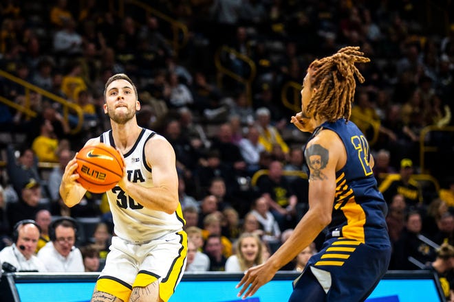 Iowa guard Connor McCaffery, left, shoots a 3-point basket as North Carolina A&T guard Demetric Horton defends during a NCAA men's basketball game, Friday, Nov. 11, 2022, at Carver-Hawkeye Arena in Iowa City, Iowa.