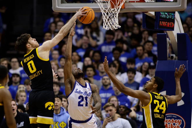 Iowa ' s Filip Rebraca, left, blocks a shot by Seton Hall ' s Femi Odukale (21) as Kris Murray, right, defends during the first half of a college basketball game, Wednesday, Nov. 16, 2022, at the Prudential Center in Newark, N.J. Iowa beat Seton Hall, 83-67.
