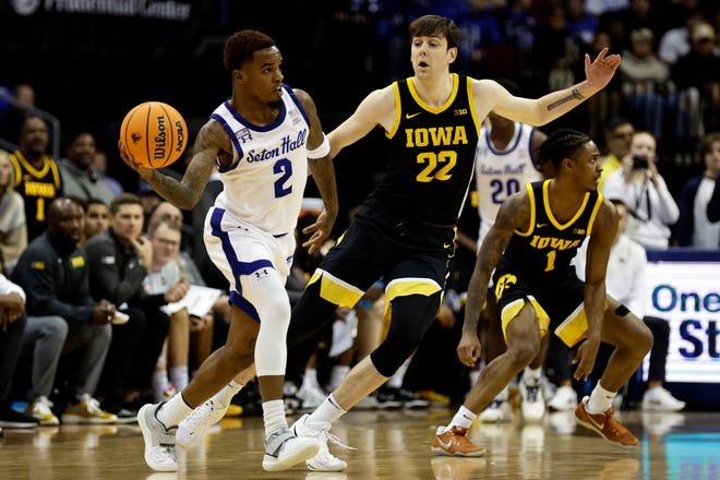 Seton Hall guard Al-Amir Dawes (2) passes around Iowa forward Patrick McCaffery (22) during the first half of an NCAA college basketball game, Wednesday, Nov. 16, 2022, at the Prudential Center in Newark, N.J.