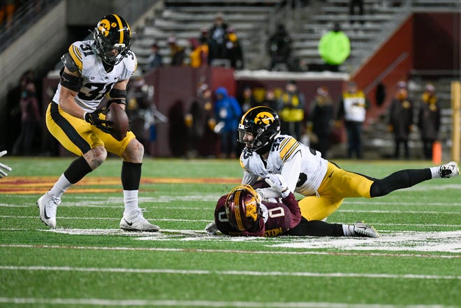 Iowa linebacker Jack Campbell (31) intercepts a pass intended for Minnesota wide receiver Le'Meke Brockington (0) after it was deflected by Iowa defensive back Riley Moss (33) during the second half an NCAA college football game, Saturday, Nov. 19, 2022, at Huntington Bank Stadium in Minneapolis, Minn.