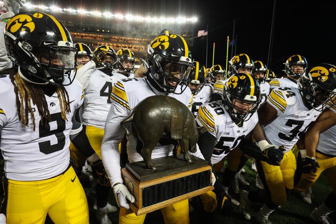 Iowa Hawkeyes players celebrate with the Floyd of Rosedale after defeating the Minnesota Golden Gophers, Saturday, Nov. 19, 2022, at Huntington Bank Stadium in Minneapolis, Minn.