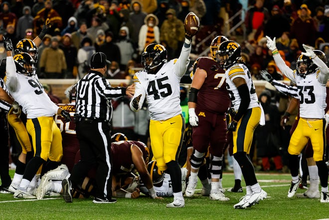 Iowa defensive lineman Deontae Craig (45) holds up the ball after recovering a fumble by Minnesota running back Mohamed Ibrahim while celebrating with teammates Yahya Black, Kaevon Merriweather and Riley Moss in the fourth quarter of the game at Huntington Bank Stadium on November 19, 2022 in Minneapolis, Minnesota. The Hawkeyes defeated the Golden Gophers 13-10.