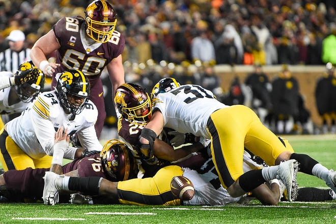 Minnesota running back Mohamed Ibrahim, second from right, fumbles the ball as he is hit by Iowa linebacker Jack Campbell (31) during the second half an NCAA college football game, Saturday, Nov. 19, 2022, at Huntington Bank Stadium in Minneapolis, Minn.