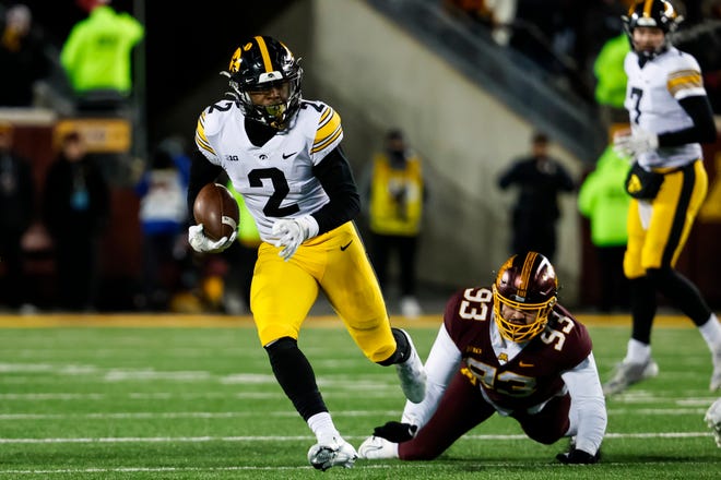 Iowa running back Kaleb Johnson, left, runs with the ball past a tackle from Minnesota's Kyler Baugh in the third quarter of the game, Saturday, Nov. 19, 2022, at Huntington Bank Stadium in Minneapolis, Minn. The Hawkeyes defeated the Golden Gophers 13-10.