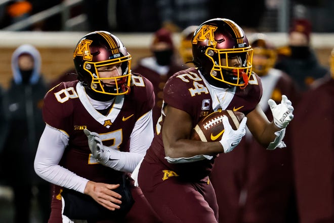 Minnesota quarterback Athan Kaliakmanis, left, hands the ball to running back Mohamed Ibrahim against the Iowa Hawkeyes in the fourth quarter of the game, Saturday, Nov. 19, 2022, at Huntington Bank Stadium in Minneapolis, Minn.