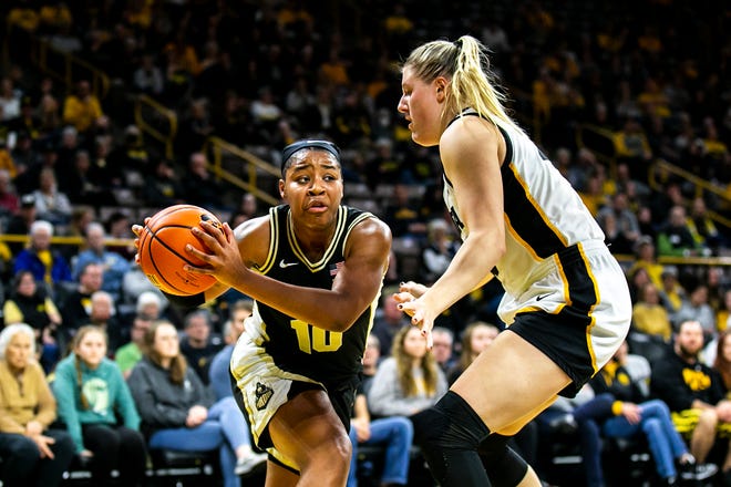 Purdue guard Jeanae Terry, left, passes the ball as Iowa center Monika Czinano defends during a NCAA Big Ten Conference women's basketball game, Thursday, Dec. 29, 2022, at Carver-Hawkeye Arena in Iowa City, Iowa.