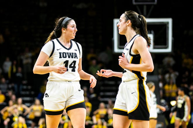Iowa's McKenna Warnock, left, talks with teammate Caitlin Clark during a NCAA Big Ten Conference women's basketball game against Purdue, Thursday, Dec. 29, 2022, at Carver-Hawkeye Arena in Iowa City, Iowa.