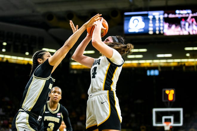 Iowa's McKenna Warnock, right, shoots the ball during a NCAA Big Ten Conference women's basketball game against Purdue, Thursday, Dec. 29, 2022, at Carver-Hawkeye Arena in Iowa City, Iowa.