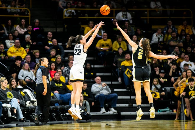 Iowa guard Caitlin Clark (22) makes a 3-point basket as Purdue guard Cassidy Hardin (5) defends during a NCAA Big Ten Conference women's basketball game, Thursday, Dec. 29, 2022, at Carver-Hawkeye Arena in Iowa City, Iowa.