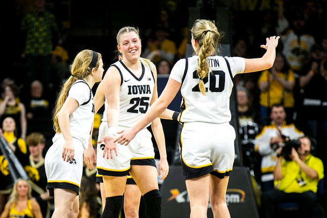Iowa center Monika Czinano (25) celebrates with teammates Molly Davis, left, and guard Kate Martin (20) during a NCAA Big Ten Conference women's basketball game against Purdue, Thursday, Dec. 29, 2022, at Carver-Hawkeye Arena in Iowa City, Iowa.